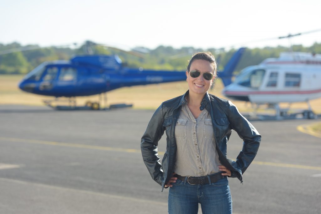  Woman near Helicopter in Black Jacket and Blue Jeans- What to Wear on a Helicopter Ride