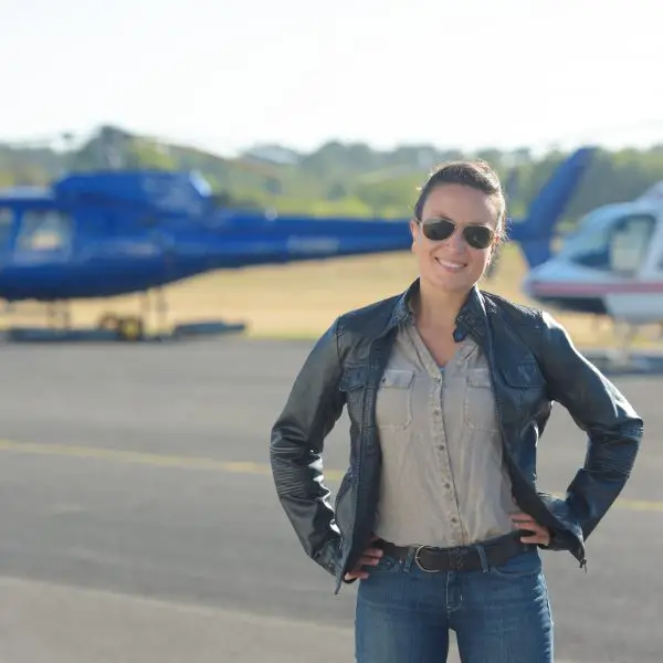 Woman near Helicopter in Black Jacket and Blue Jeans- What to Wear on a Helicopter Ride
