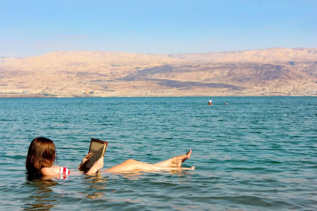 Woman Reading a book while floating on the Dead Sea - Bucket List Ideas